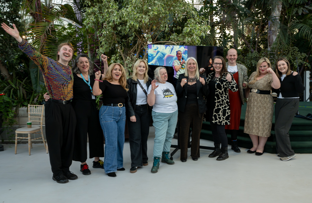 DaDa Team gather at Sefton Park Palm house. They are cheering, showing strong poses and 'rage' faces