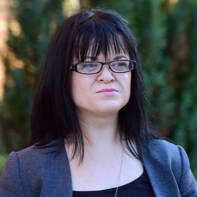 Headshot of Dr Erin Pritchard with dark hair and glasses