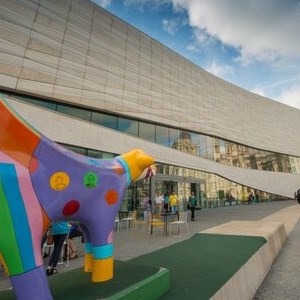 An image taken outside the museum of Liverpool including a colourful Superlambanana sculpture and passersby