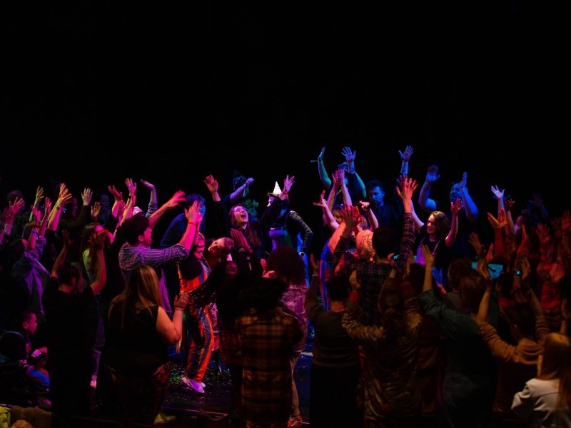 Young people onstage wearing party hats