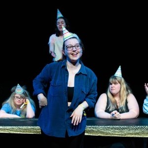 Young people onstage wearing party hats