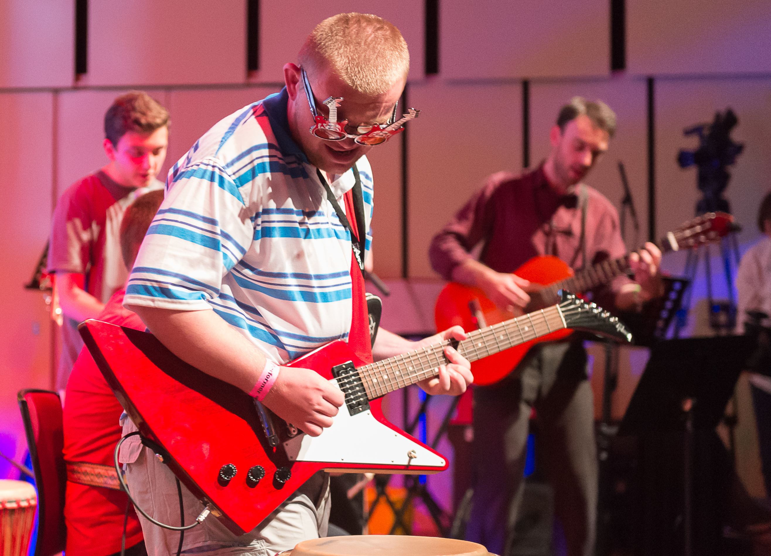 A young man onstage playing an electric guitar