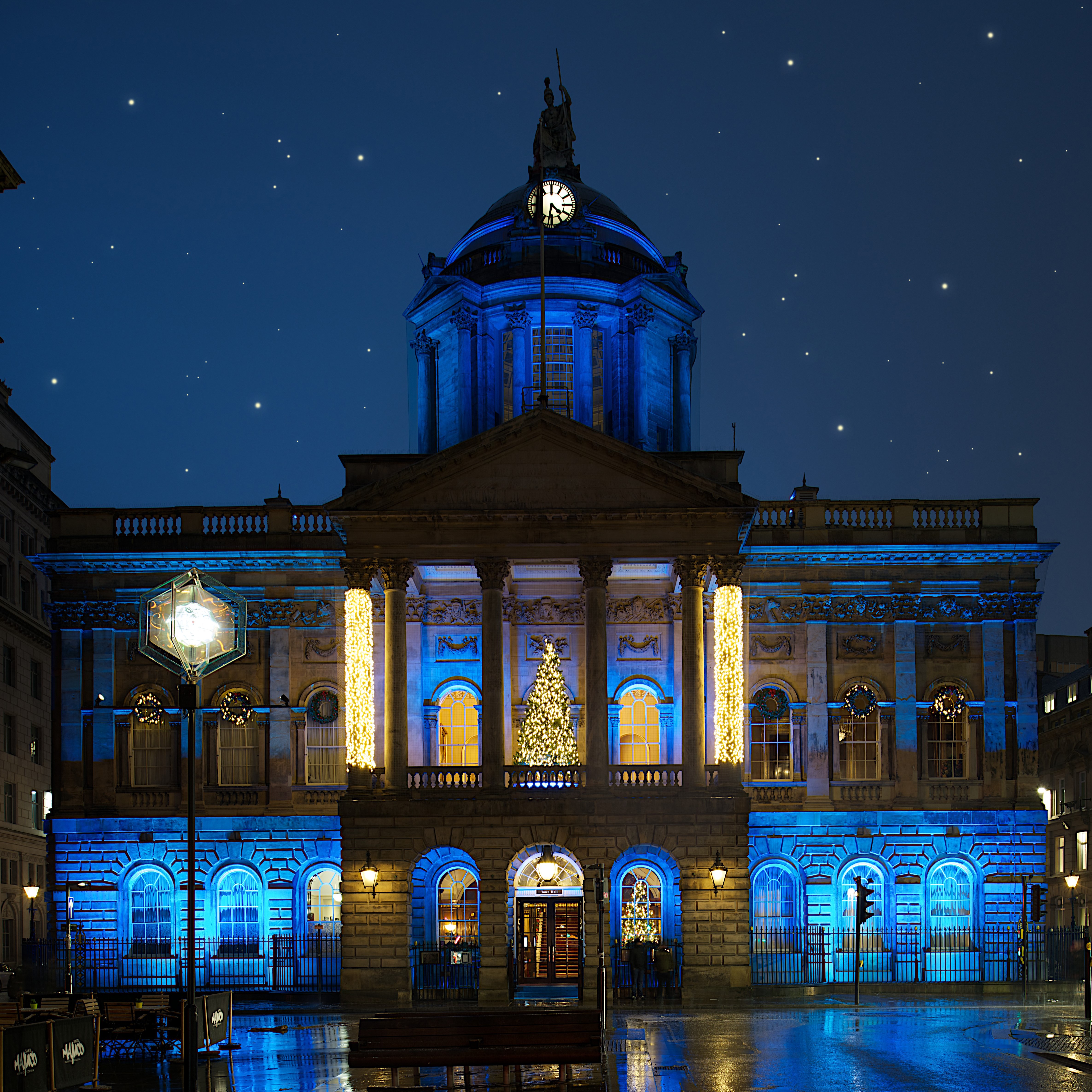 Image of Liverpool Town Hall at night lit up yellow and blue