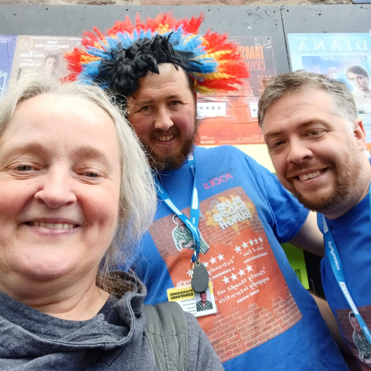 Image of DaDa’s Access & Support Coordinator is to the left with grey hair tied back and a black jumper. She stands next to two of the team from blue 