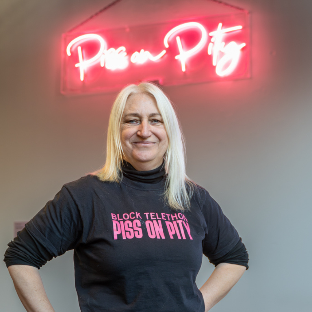 Zoe stands in front of her 'Piss on Pity' neon