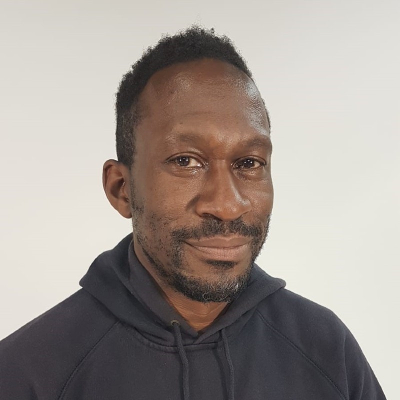 David Ellington, a black man wearing a black top and smiling