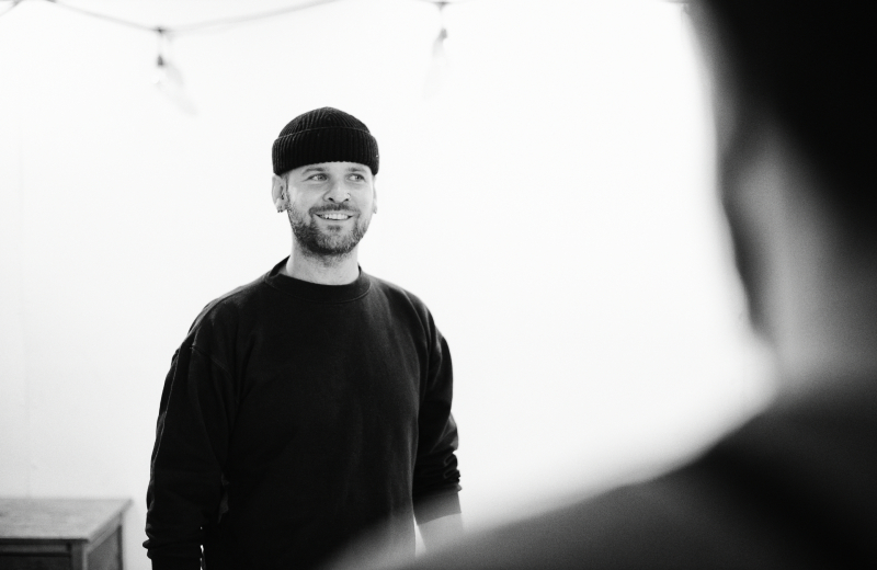 Black and white photo of man in beany hat smiling