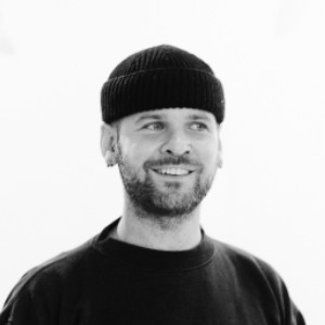 Black and white photo of man in beany hat smiling