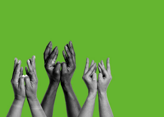 a photograph of hands reaching into the air on a green background.