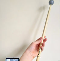A photo of a hand holding a wooden drum stick