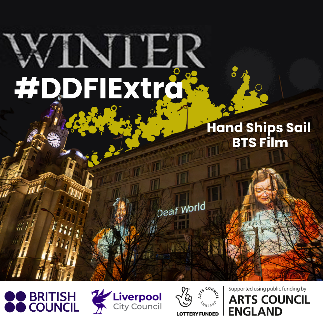 Two women gesturing in BSL have the words 'Deaf World' between them. They are projected in film onto the Cunard Building in Liverpool