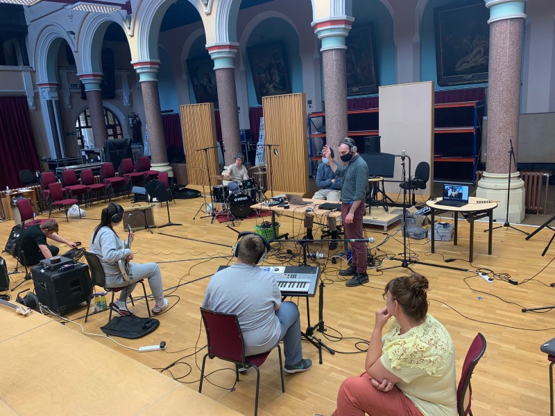 A group of musicians practice in a hall