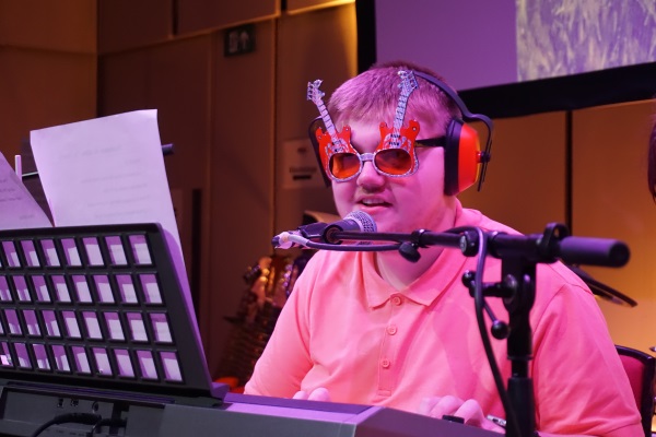 Young man wearing guitar shaped sunglasses at the keyboard