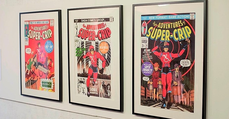 Posters in the style of a super-hero comic front-page depicting 'Super Crip', a disabled super-hero in a red outfit and black mask. 
